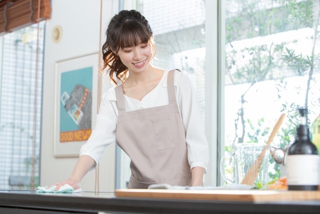 台の上を布巾で拭く女性