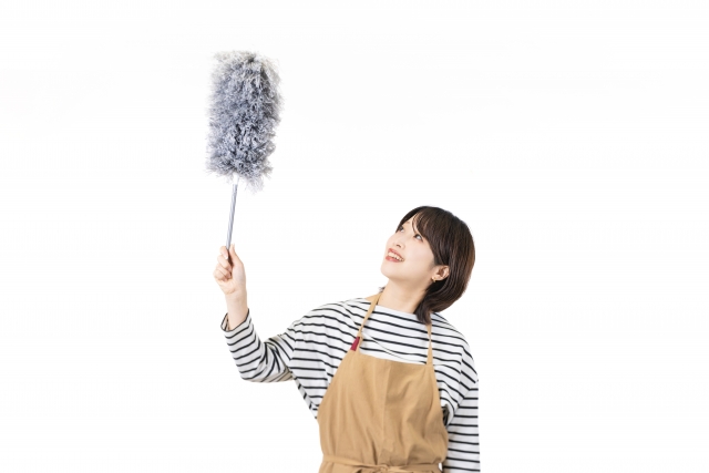 マイクロファイバーで壁のほこりを掃除する女性