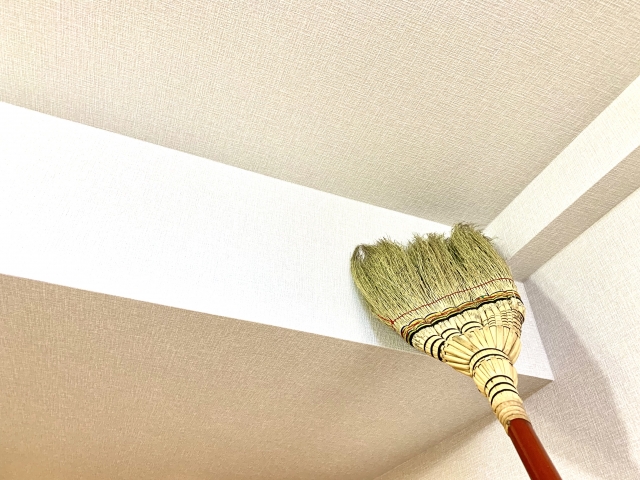天井のほこりをほうきで取る掃除